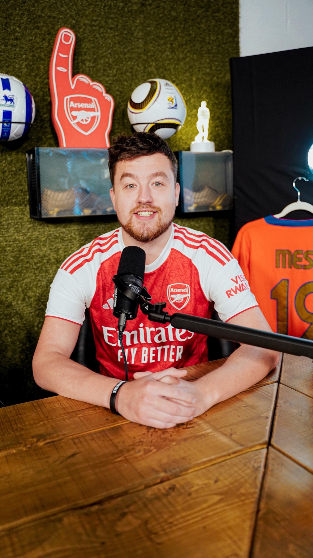 Rory Cook at the podcast desk in an Arsenal shirt